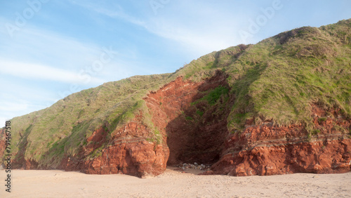 Pared rocosa de arcilla en loma de hierba en playa