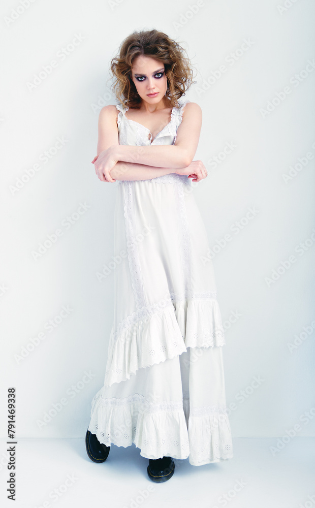 Portrait of attractive strange girl. Beautiful odd young woman in white dress standing at wall Portrait of attractive strange girl. Beautiful odd young woman in white dress standing at wall