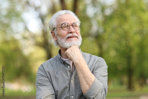 Portrait of happy grandpa with glasses in park