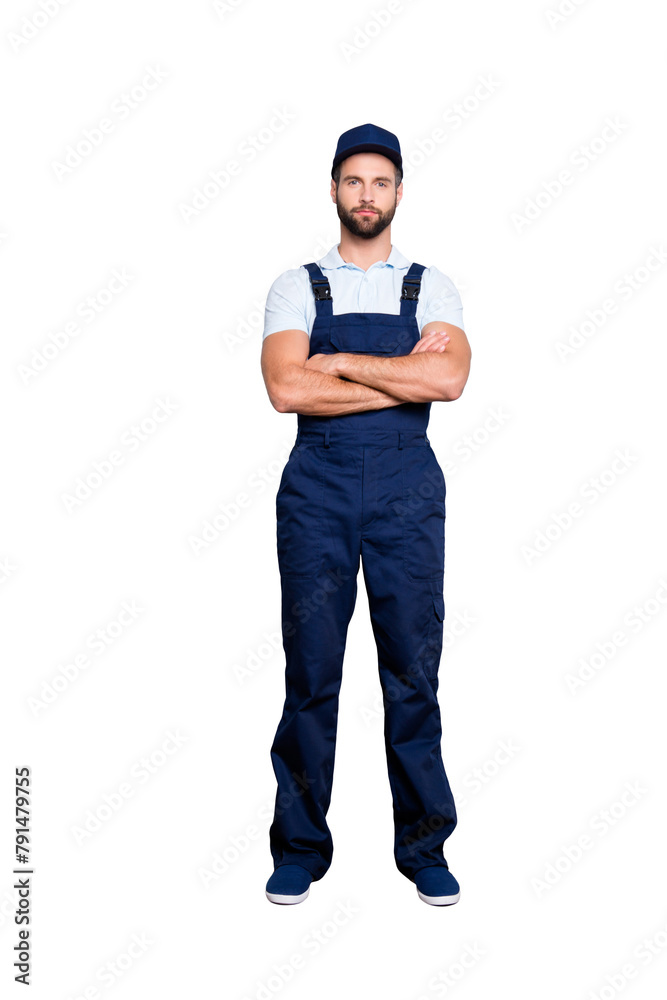 Full size fullbody portrait of strict muscular deliver in blue uniform looking at camera, having his arms crossed, isolated on grey background
