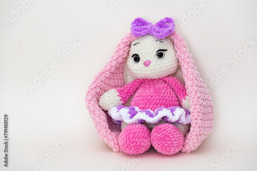Bunny. Hobby crochet. Handmade. Amigurumi. Pink knitted rabbit. Soft toy. Long ears. Crocheting of soft toys