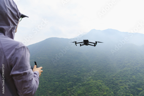 Woman photographer remote control a flying drone in spring forest