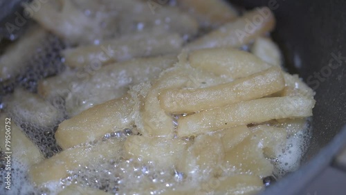 Cooking french fries potatoes in deep fryer. Closeup photo