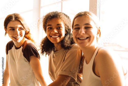 Happy cute girls of different races are laughing and chatting photo