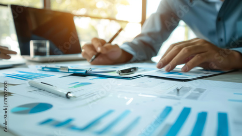 Financial Advisor Discussing Tax Systems A financial advisor discussing intricate tax systems to clients, with papers and graphs. Suitable for financial advisory firm marketing.Background 