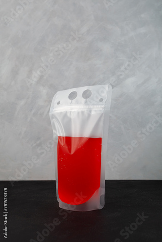 Red adult alcoholic drink in spill-proof disposable drink pouch. Fruit berry fermenting lemonade. Wine Slushy in plastic bag. Perfect for beach, party, picnics and gatherings
