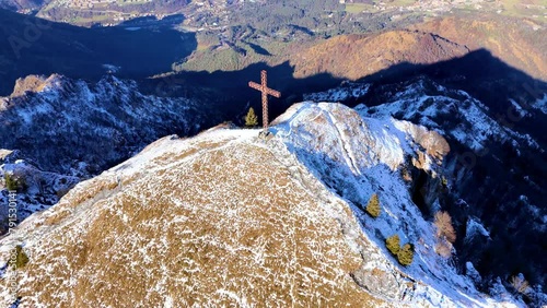 Pull-back drone footage of the cross on the summit of Pizzo Formico mountain in Lombardy, Italy photo