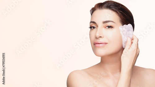 Elegant Woman Using Gua Sha Stone for Facial Skincare