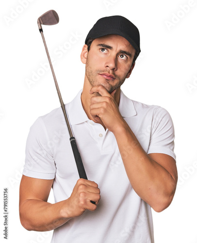 Young Hispanic man with golf club looking sideways with doubtful and skeptical expression.
