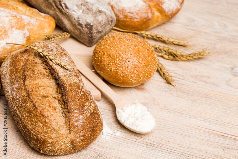 Homemade natural breads. Different kinds of fresh bread as background, perspective view with copy space Homemade natural breads. Different kinds of fresh bread as background, perspective view with copy space