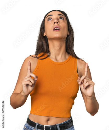 Hispanic young woman pointing upside with opened mouth.