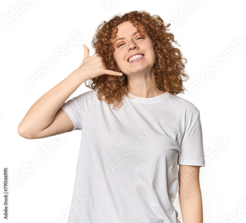 Young Caucasian redhead woman showing a mobile phone call gesture with fingers.