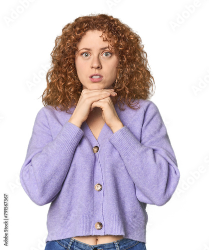 Young Caucasian redhead woman praying for luck, amazed and opening mouth looking to front.
