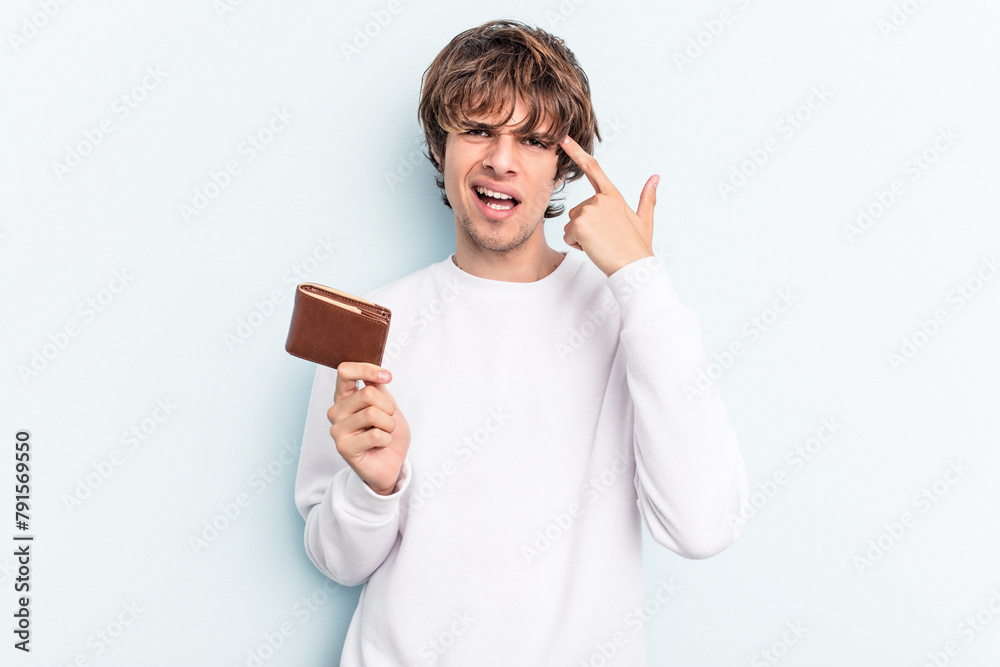 Young caucasian man holding a ballet isolated on blue background showing a disappointment gesture with forefinger. Young caucasian man holding a ballet isolated on blue background showing a disappointment gesture with forefinger.