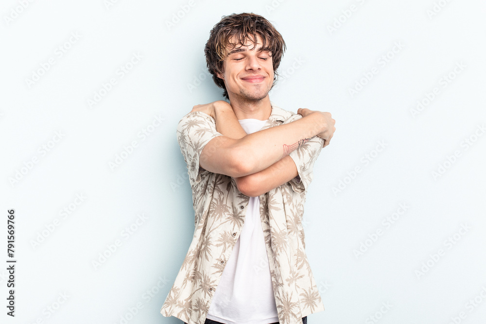 Young caucasian man isolated on blue background hugs, smiling carefree and happy. Young caucasian man isolated on blue background hugs, smiling carefree and happy.
