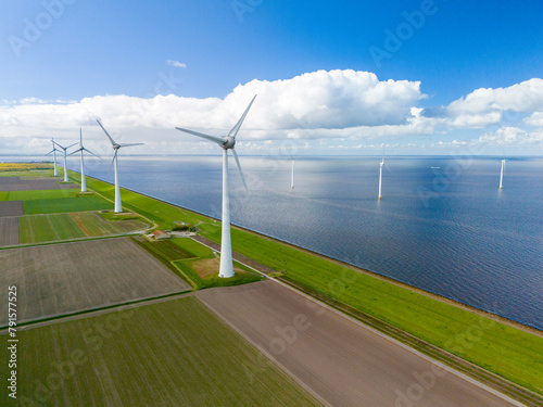 A mesmerizing aerial view of a wind farm near the ocean, where rows of elegant windmill turbines catch the breeze, harnessing clean energy photo