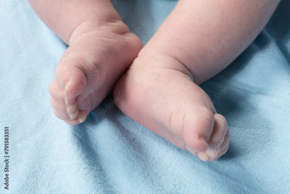 Close up view of newborn baby legs on a bed. Close up view of newborn baby legs on a bed.