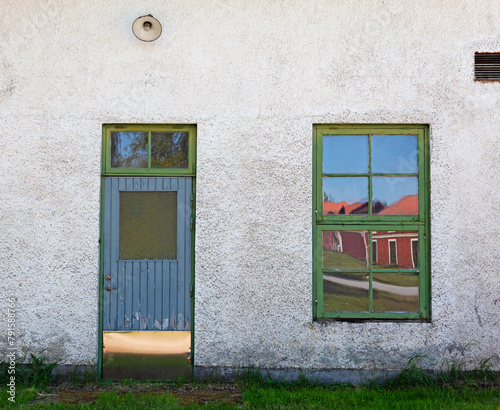 A door and a window to an old whitewashed house in Robertsfors