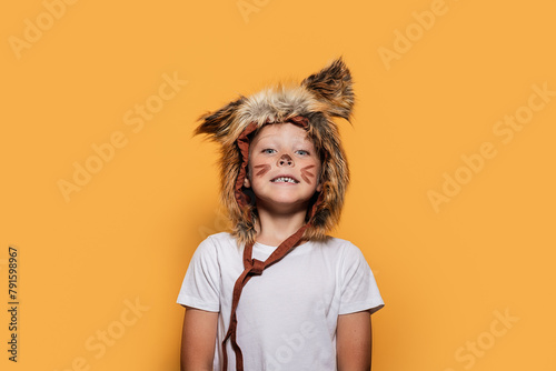 Playful child in animal costume against yellow background