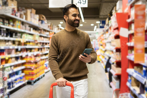 Smiling shopper with smartphone in store aisle