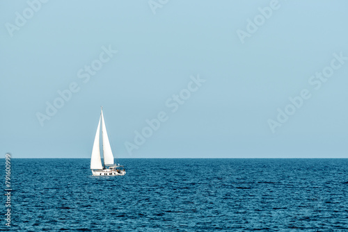 White sailboat at the beautiful blue sea.