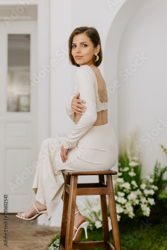 Elegant girl model in studio with green decor and white wall
