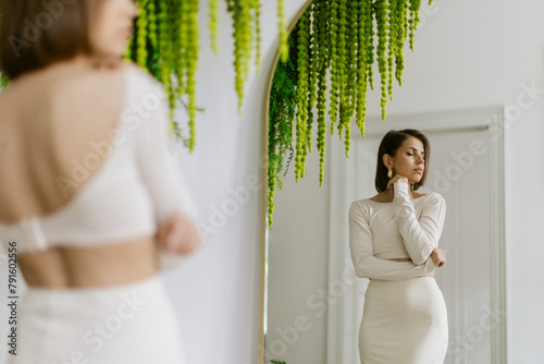Elegant girl model in studio with green decor and white wall