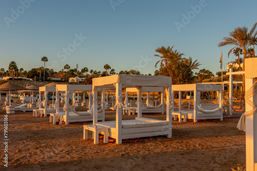 Tropical beach with umbrelles during sunset. Tourism and travel.