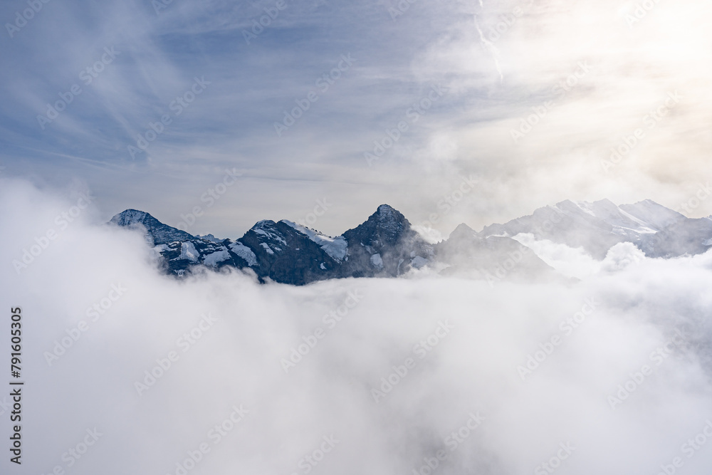 View of Swiss Alps over clouds on a bright sunny day from Schilthorn summit in Switzerland