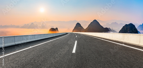Asphalt highway road and karst mountain with sky clouds at sunrise. Panoramic view.