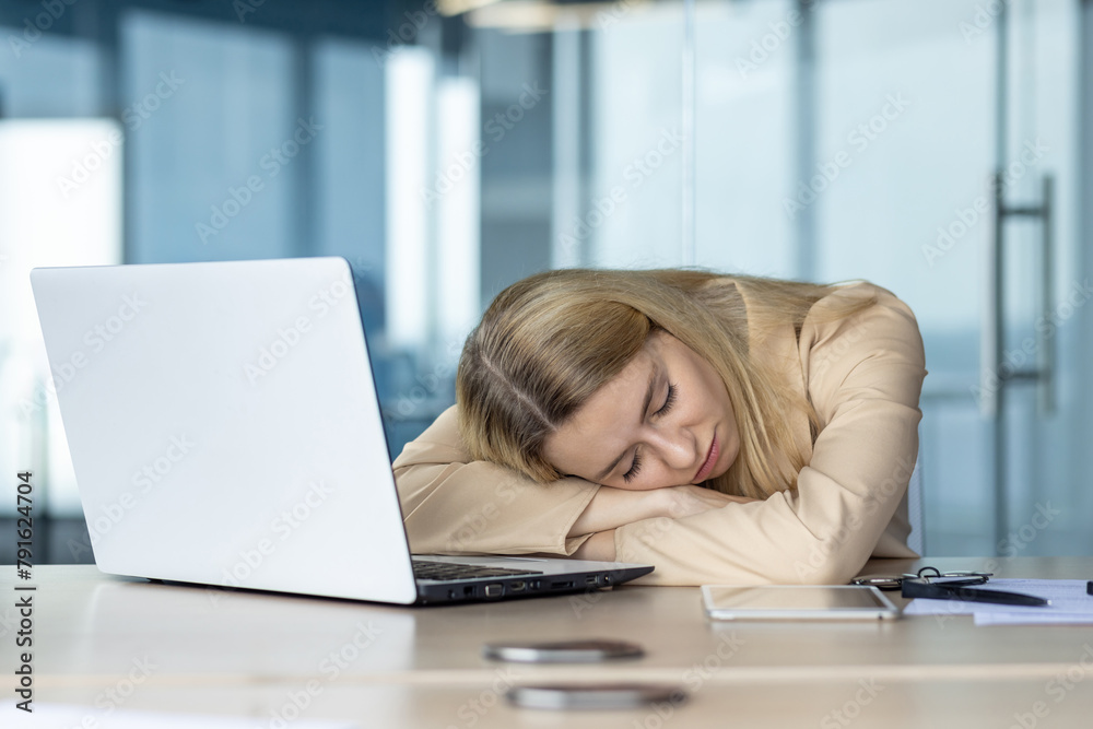 Exhausted young woman sleeping at modern office desk Exhausted young woman sleeping at modern office desk