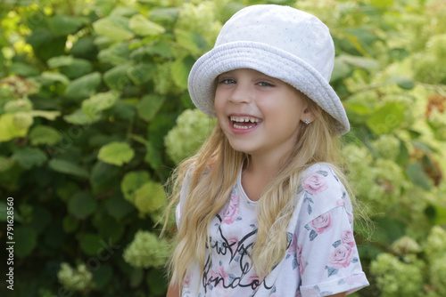 Candid outdoor portrait of happy little girl with bucket hat © triocean