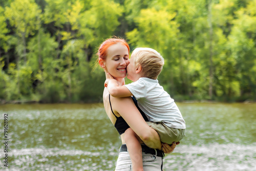 Young mother and little child kid boy son in park.Happy family playing,having fun,holding on hands,hugging in nature against trees,lake.parenting,child care.Healthy babytime outdoors.