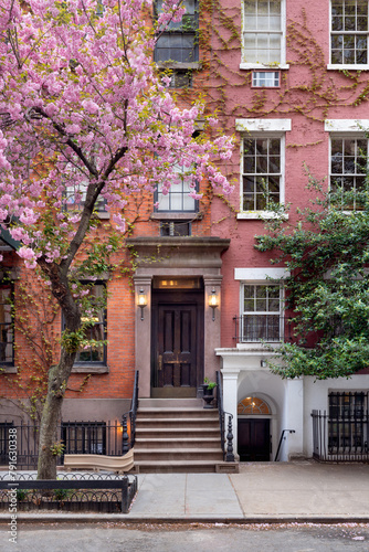Townhouse in Greenwich Village Historic District with blooming trees in spring. West Village, Manhattan, New York City