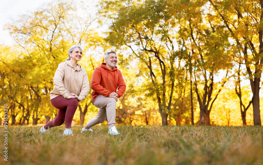 Fototapeta premium Happy senior husband and wife in sportive outfits play sports outdoors in city park.