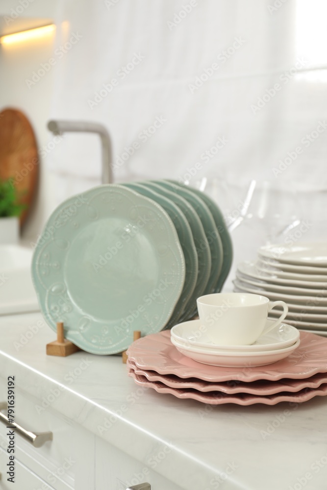 Clean plates and cup on white marble countertop in kitchen Clean plates and cup on white marble countertop in kitchen