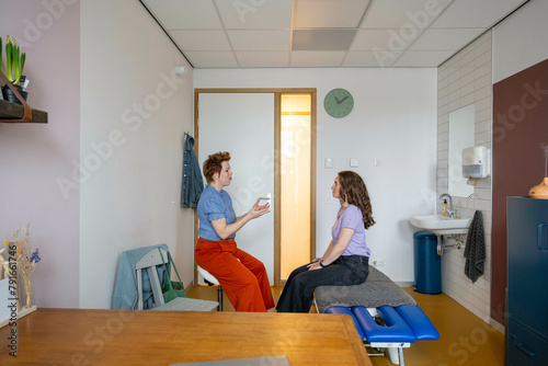 Medical consultation between a practitioner and a patient in a clinic room. photo