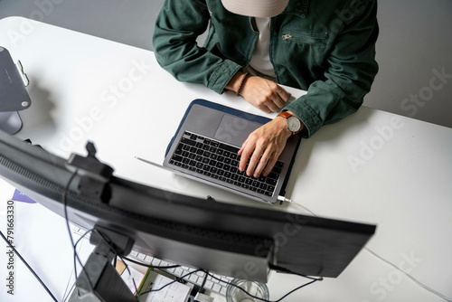 Man using laptop at a modern workspace photo