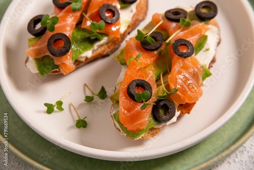 Bruschetta with red fish, cottage cheese, olives and herbs. Italian Cuisine. Healthy eating.
