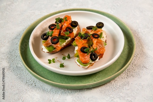 Bruschetta with red fish, cottage cheese, olives and herbs. Italian Cuisine. Healthy eating.