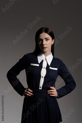 Portrait of attractive caucasian young brunette woman in school uniform in studio. Elegant woman posing. Pretty stylish model. Beauty, Style, Fashion, Luxury