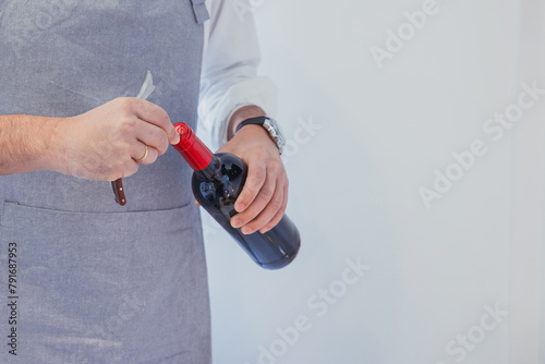Man opening wine bottle for dinner preparation photo
