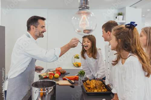 Joyful family moment cooking chicken in kitchen photo