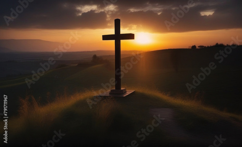 a cross on a hill with sunlight far behind