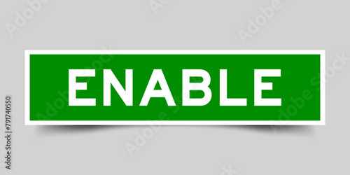 Green color square label sticker with word enable that inserted in gray background