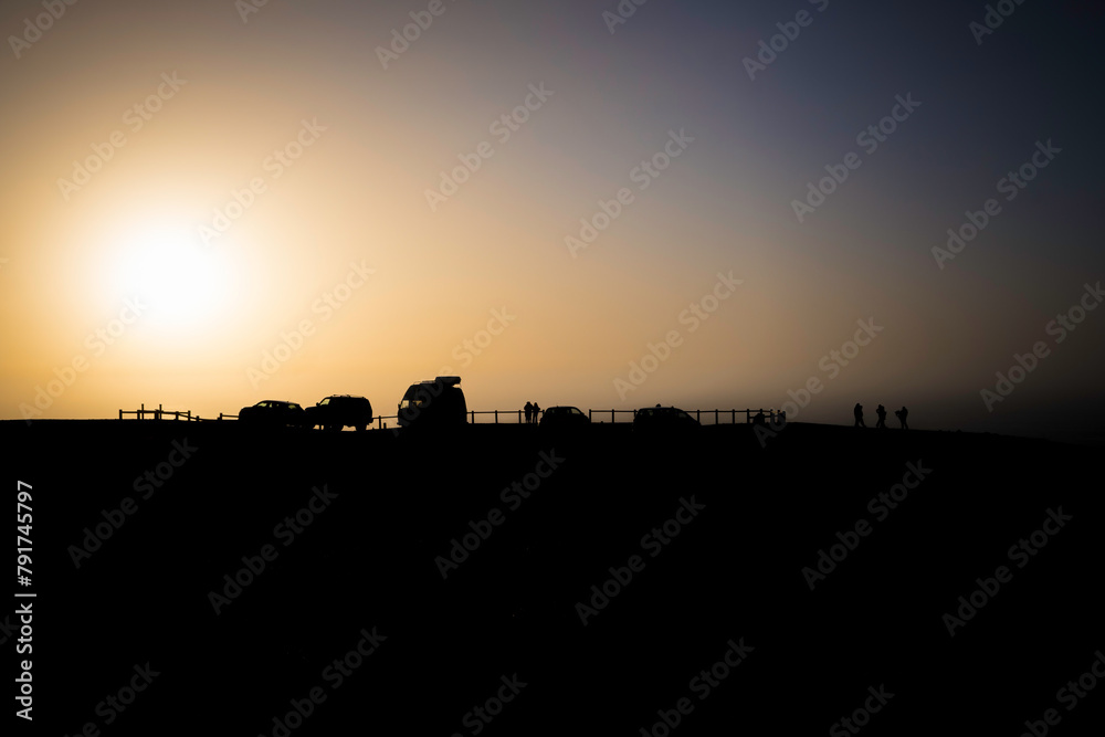 Silhouette of cars and people on the Cordoama viewpoint in Vila do Bispo, Algarve, enjoying a sunset.