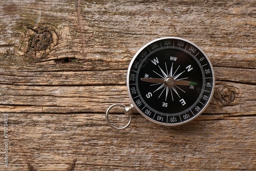 One compass on wooden table, top view. Space for text