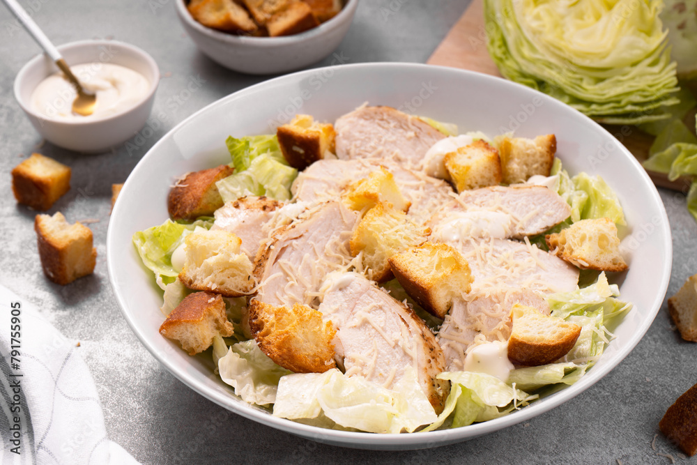 Chicken Caesar Salad in a Bowl with Parmesan Cheese, Dressing and Croutons Chicken Caesar Salad in a Bowl with Parmesan Cheese, Dressing and Croutons