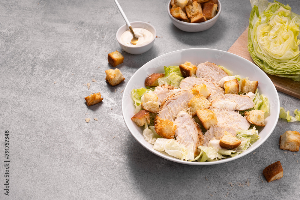 Chicken Caesar Salad in a Bowl with Parmesan Cheese, Dressing and Croutons