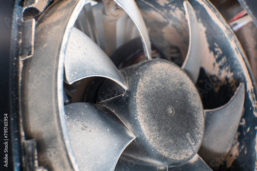 A detailed shot of a grimy metal computer fan resting on a clean white tabletop, reminiscent of automotive tire components like alloy wheels, rims, and hubcaps photo
